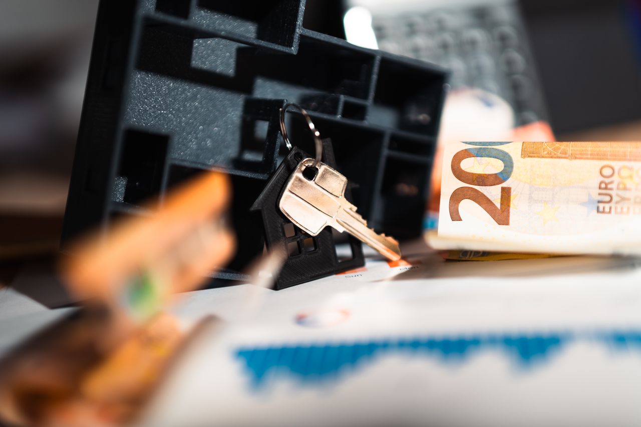 why-choose-us Keys with a house model, Euro bills, and charts suggesting real estate and financial themes.