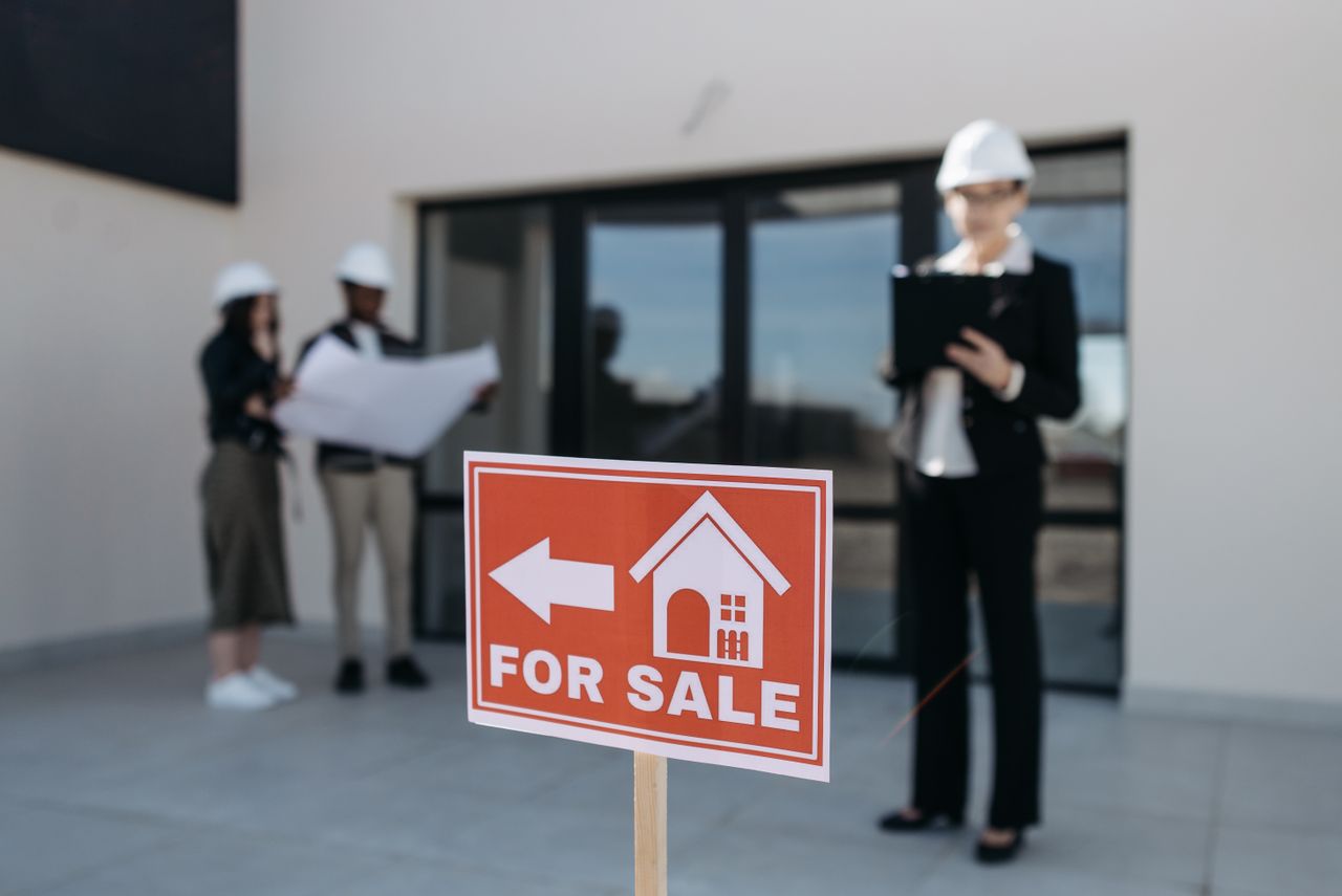 services-03 Three real estate professionals inspecting a property for sale with a focus on the business aspect.